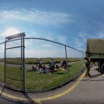 A distorted image of military vehicles in a parking lot next to a fence.