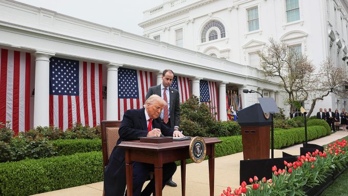 President Donald Trump signs an executive order on tariffs in the Rose Garden of the White House