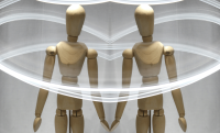 wooden artist's mannequin surrounded by trails of light. The photo is mirrored to create the two mannequins with their hands touching.
